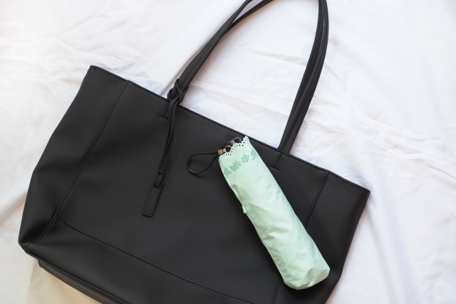 Compact foldable umbrella clipped to a tote bag for everyday carry in Japan