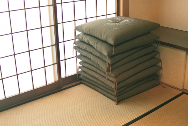 Stacked zabuton floor cushions stored neatly in a Japanese tatami room