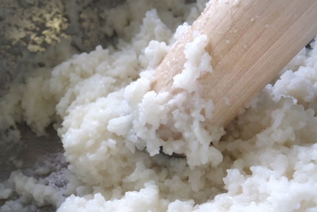 Close-up of partially mashed rice showing visible grains in the mixture used for ohagi