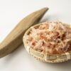 katsuobushi flakes in a bamboo basket with a traditional shaving tool