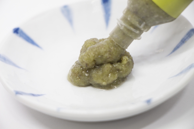 Tube wasabi paste with a coarse texture squeezed onto a plate