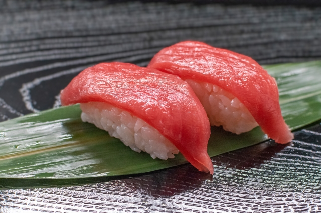 Two pieces of tuna nigiri sushi showing how Japanese rice holds its shape beneath the fish.