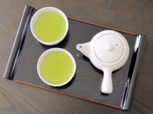 Sencha served in two Japanese teacups with a white kyusu on a tray