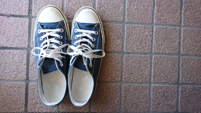 Shoes placed on the tiled floor of a genkan before stepping into the home.