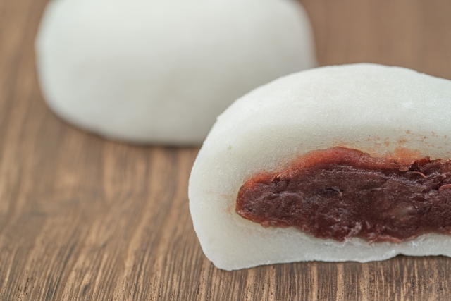 Cross-section of a traditional daifuku showing sweet red bean paste inside a soft white outer layer