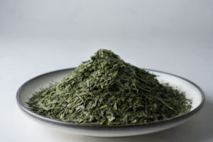 Deep-steamed fukamushi-cha tea leaves on a small plate.