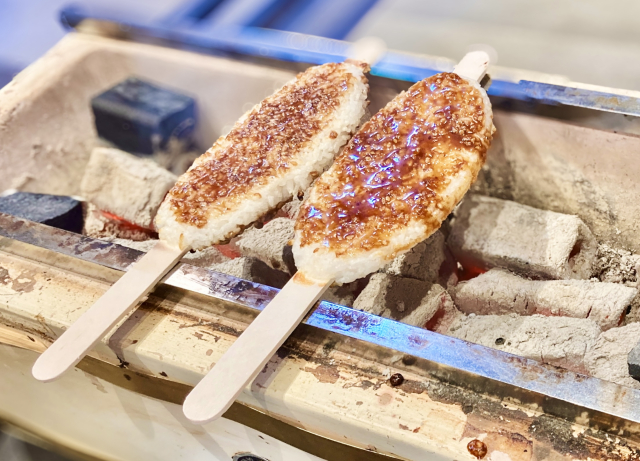 Gohei mochi made from crushed ordinary rice, coated with sauce, and grilled on wooden sticks