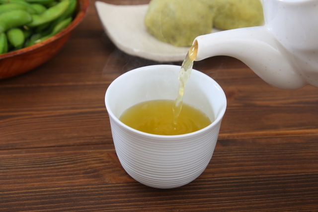 Sencha being poured at a casual Japanese table with everyday food in the background.