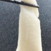 Traditional Japanese mochi stretching from chopsticks to show its soft, elastic texture