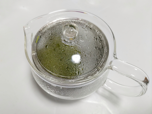 Sencha steeping in a glass teapot with the lid on.