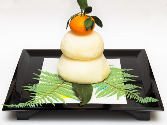 alt="Traditional kagami mochi display with an orange on top, prepared for the Japanese New Year season"
