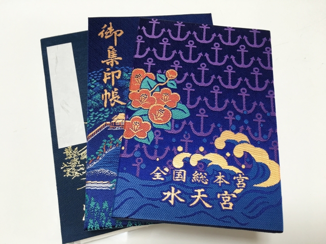A beautiful navy blue Goshuincho from Suitengu Shrine in Tokyo, featuring an embroidered design of anchors, camellia flowers, and ocean waves.