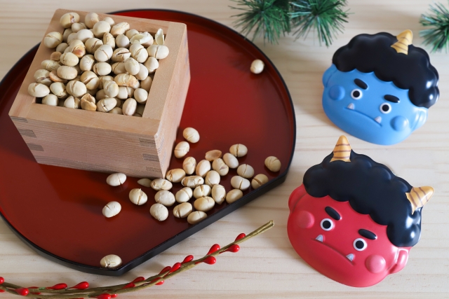 Roasted soybeans in a masu box with red and blue oni masks