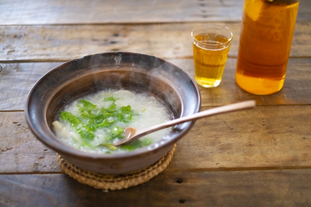 A steaming bowl of nanakusa-gayu served with tea as a simple, light seasonal meal.