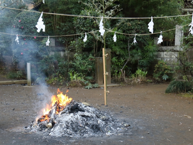 Otakiage ritual burning at a Shinto shrine, with a small fire used to burn old charms and offerings