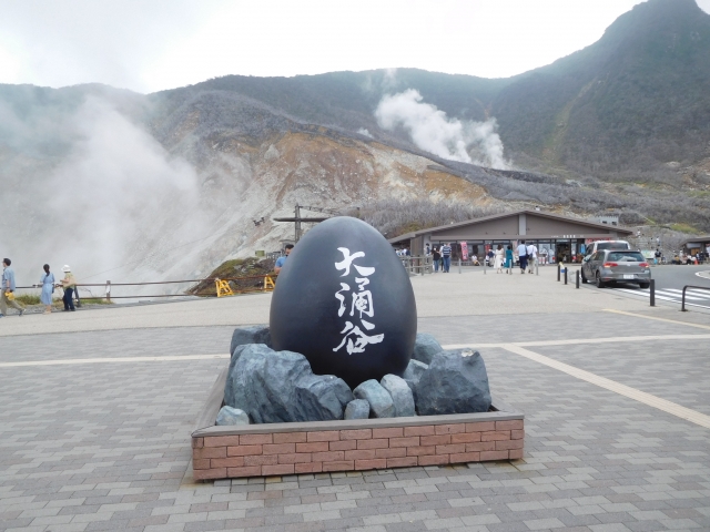Owakudani volcanic valley in Hakone with steam vents and the large “Owakudani” stone monument