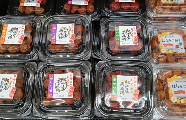 Packages of umeboshi displayed in a Japanese supermarket, showing how ready-made pickles are commonly bought for home meals.