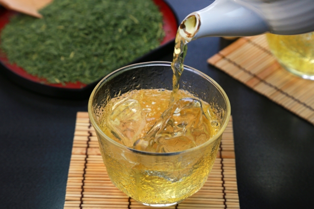 Hot green tea being poured over ice for the rapid chill method