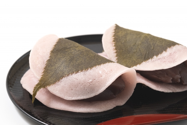 Close-up of Chōmeiji-style sakura mochi with thin pink wrapper folded over red bean paste