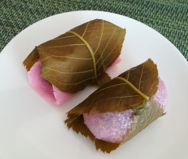 Two types of sakura mochi showing different shapes and leaf wrapping styles