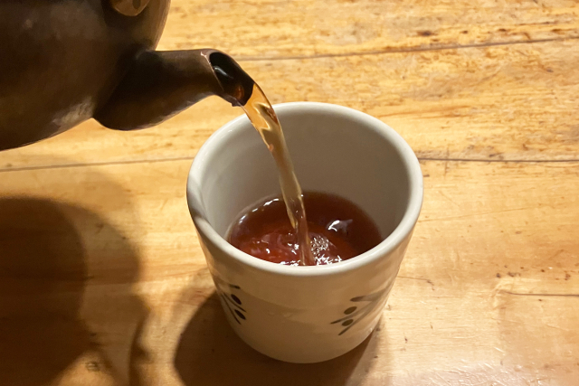 Hot hojicha being poured into a ceramic cup