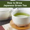 A cup of Japanese green tea served in a yunomi cup beside a kyusu teapot