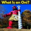 Large red oni statue holding an iron club, wearing tiger-skin pants, symbolizing fear and power in Japanese folklore