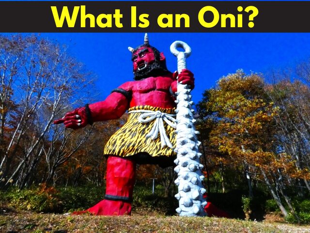 Large red oni statue holding an iron club, wearing tiger-skin pants, symbolizing fear and power in Japanese folklore