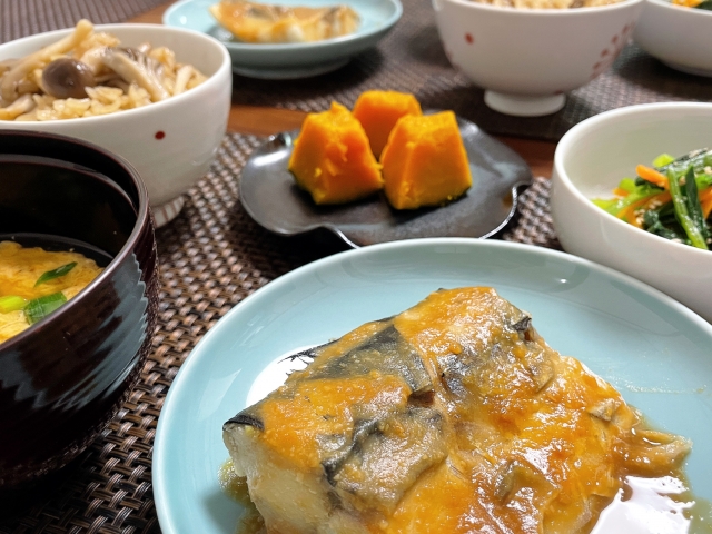 Japanese home-style meal with miso-glazed fish, miso soup, mushroom rice, pumpkin, and vegetable side dishes.