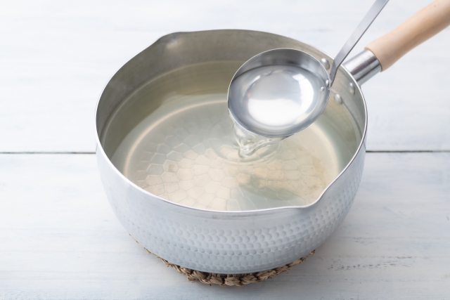Ladle lifting clear ichiban dashi broth from a pot