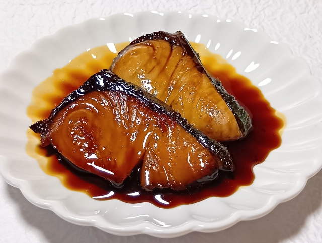Glossy teriyaki-style buri served with a dark soy-based sauce.