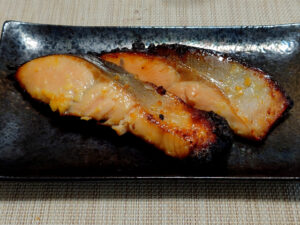 Two pieces of Saikyo-yaki grilled fish with golden surfaces and lightly charred edges from the sweet miso marinade.