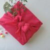 Japanese gift wrapped in bright pink furoshiki cloth, symbolizing traditional presentation culture