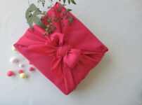 Japanese gift wrapped in bright pink furoshiki cloth, symbolizing traditional presentation culture