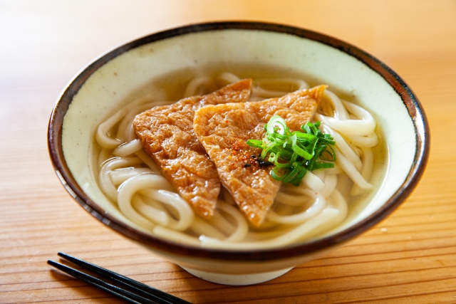 Bowl of kitsune udon with tofu and clear dashi broth
