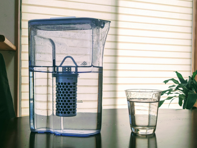 A filtered water pitcher and a glass of water on a table