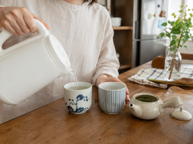 Hot water being poured into a teacup before brewing Japanese green tea