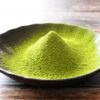 Bright green matcha powder in a bowl showing fine texture for use in desserts