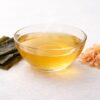 Clear awase dashi in a glass bowl with kombu and shaved katsuobushi, the classic ingredients used in combined Japanese dashi.