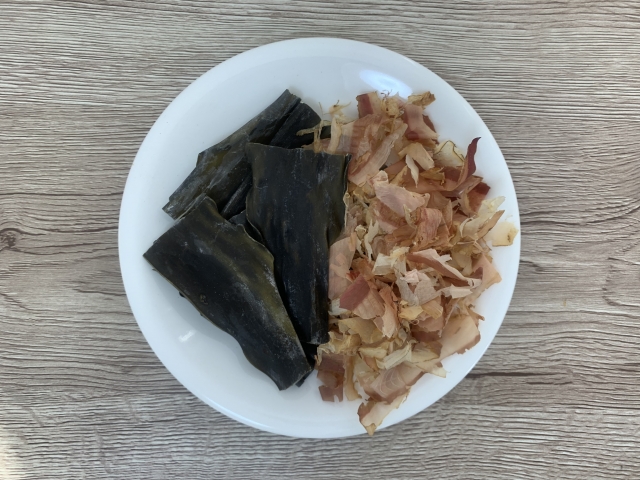 Kombu and shaved katsuobushi on a plate, the classic ingredients used to make awase dashi in Japanese cooking.