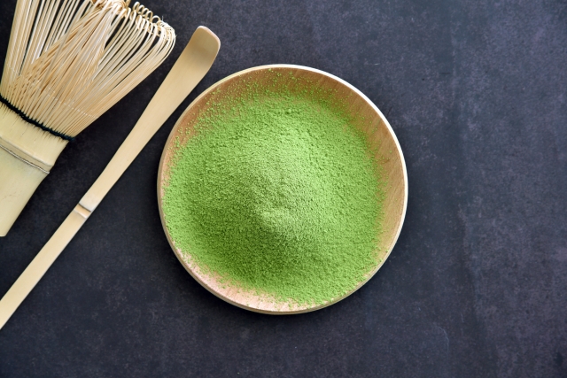 Matcha powder with bamboo whisk showing traditional preparation tools