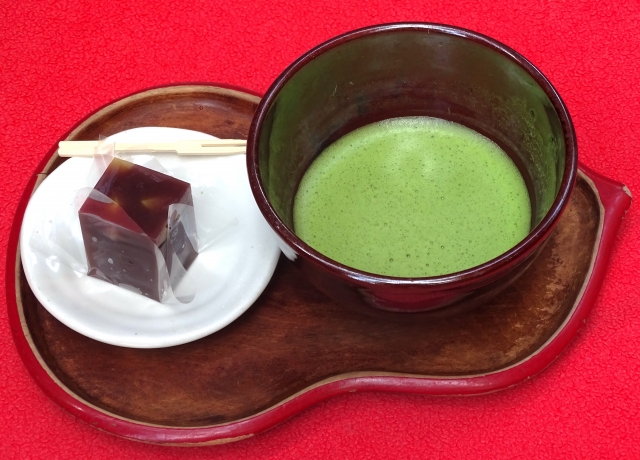 Matcha tea served with traditional Japanese sweet wagashi on a tray