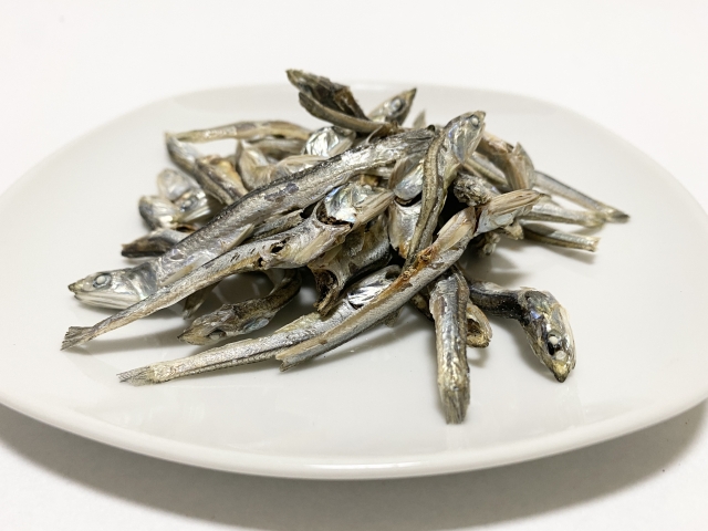 Pile of dried niboshi anchovies on a white plate