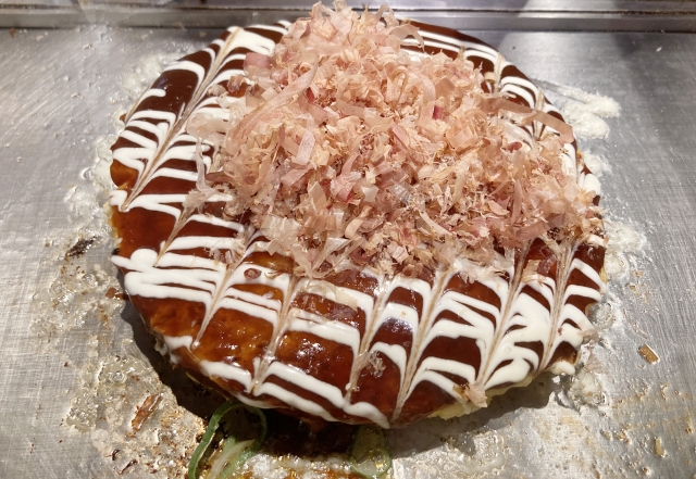 okonomiyaki topped with katsuobushi sauce and mayonnaise