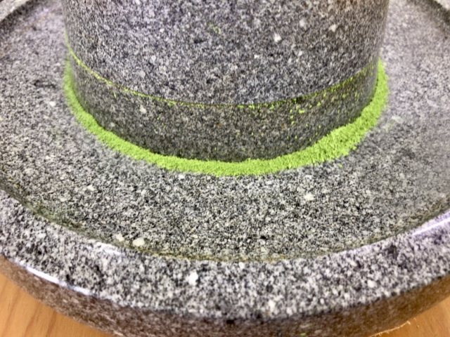 Matcha powder forming around a rotating stone mill during grinding