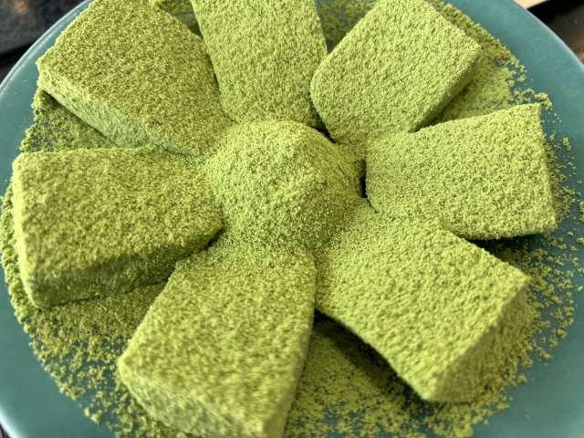 Matcha-coated warabi mochi pieces with soft and chewy texture