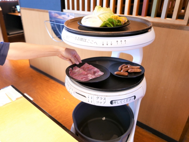 Food delivery robot serving dishes inside a modern Japanese family restaurant