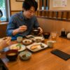 Japanese couple eating in a calm restaurant while the bill holder rests quietly on the table