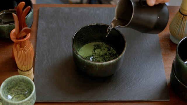 Hot water being poured into matcha, a step that affects its flavor