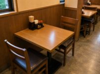 A compact two-person table in a Japanese restaurant, showing the simple and space-efficient design common in everyday dining
